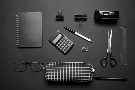 Stylish pencil case, eyeglasses and stationery on dark backgroundの写真素材