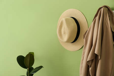 Hat and coat hanging on green wall in hallwayの写真素材