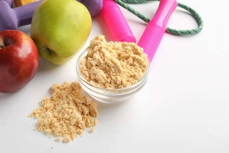 Bowl with protein powder, apples and skipping rope on white background, closeupの写真素材
