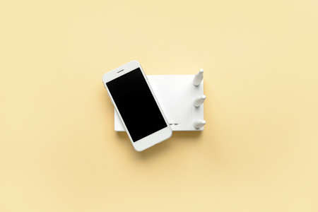 WiFi router and smartphone on color background