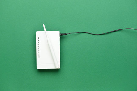 Wi-Fi router with antenna and network cable on color backgroundの写真素材