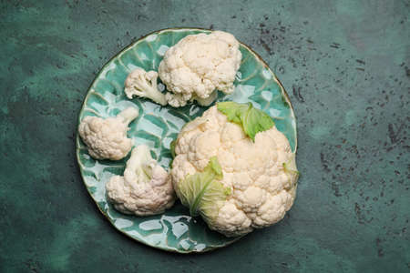 Plate with cauliflower cabbage on color background