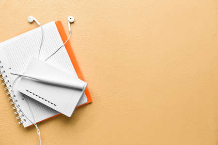 Wi-Fi router, earphones and notebook on color backgroundの写真素材
