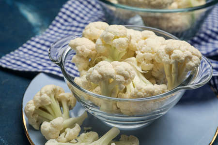 Bowl with cauliflower cabbage on color background, closeup