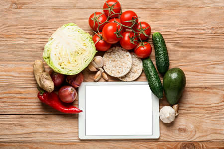 Tablet computer with blank screen and healthy food on wooden backgroundの写真素材