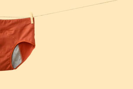 Period panties hanging on rope against color backgroundの写真素材