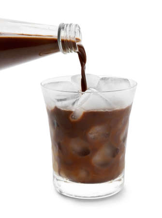 Pouring tasty chocolate milk into glass on white backgroundの写真素材