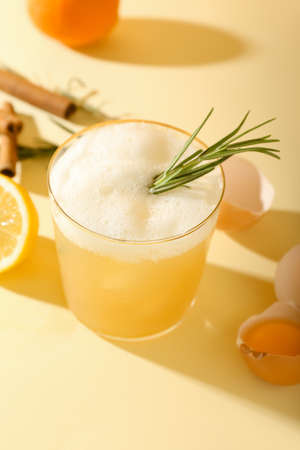 Glass of tasty whiskey sour cocktail on color backgroundの写真素材