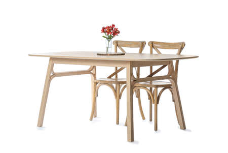 Wooden dining table with flowers and chairs on white backgroundの写真素材