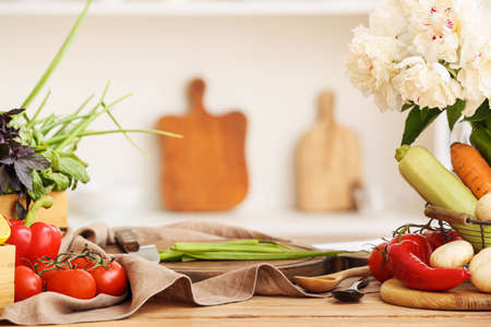 Fresh vegetables and flowers on the table in the kitchenの写真素材