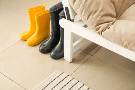 Rubber boots near sofa in hallway