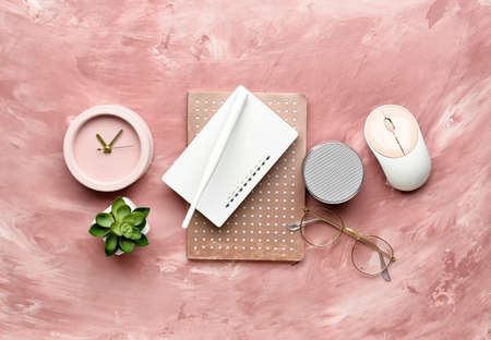 Composition with wi-fi router, speaker, clock, PC mouse and notebook on color background