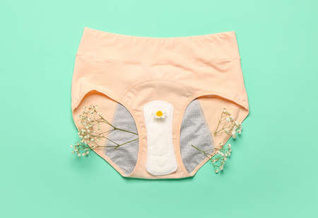 Period panties, pad and flowers on color backgroundの写真素材