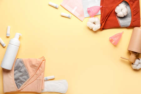 Composition with period panties, pads, tampons, menstrual cups and bottles of cosmetic products on color backgroundの写真素材