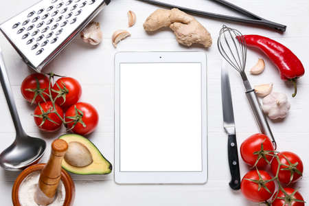 Digital recipe book, kitchen utensils and ingredients on white wooden backgroundの写真素材