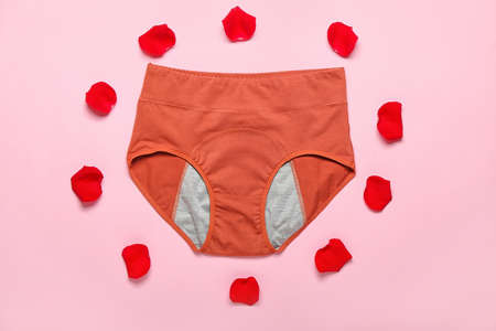 Composition with period panties and red rose petals on color backgroundの写真素材