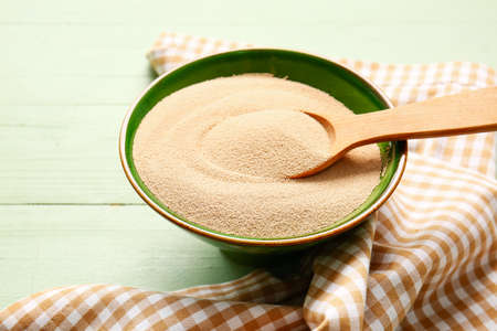 Bowl with active dry yeast on wooden backgroundの写真素材