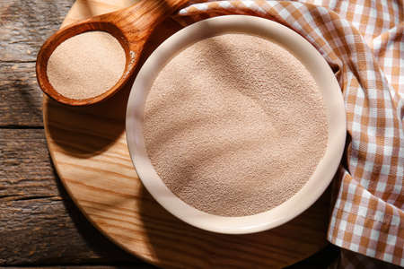 Composition with bowl of active dry yeast on wooden backgroundの写真素材