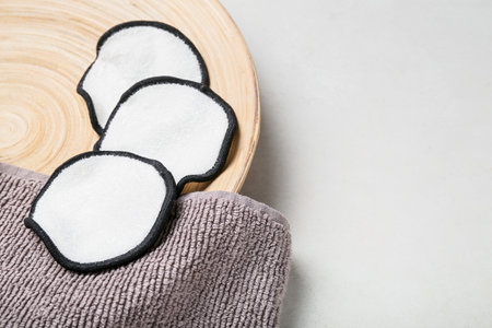 Plate with reusable cotton pads and towel on light background, closeupの写真素材