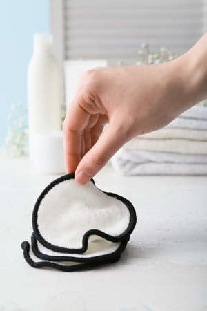 Female hand with reusable cotton pads on table, closeupの写真素材