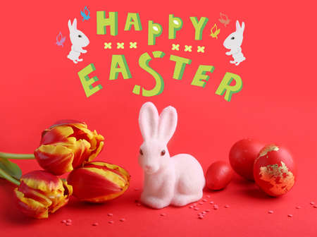 Beautiful Easter greeting card with toy bunny, tulips and eggs on red backgroundの写真素材