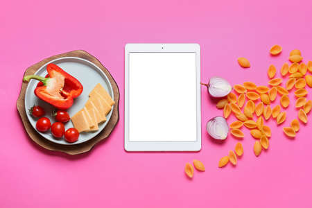 Composition with digital recipe book and food on color background