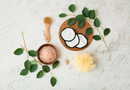 Composition with reusable cotton pads, sea salt, massage brush, sponge and eucalyptus branches on...