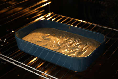 Uncooked cake with poppy seeds in oven