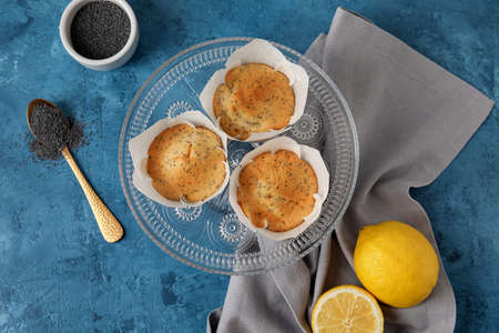 Plate with delicious poppy seed muffins on color backgroundの写真素材