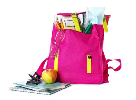 School backpack with stationery, eyeglasses, bottle of sanitizer, medical mask and apple on white...