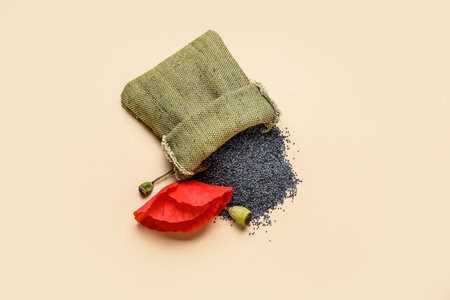 Bag with poppy seeds and flower on color backgroundの写真素材