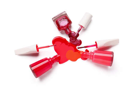 Bottles of nail polishes with brushes and blot on white background