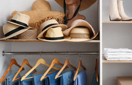 Stylish hats on shelf in wardrobeの写真素材
