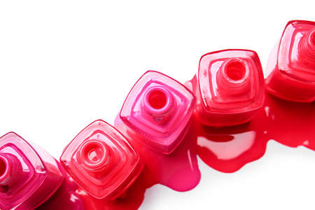 Opened bottles with spilled nail polishes on white backgroundの写真素材