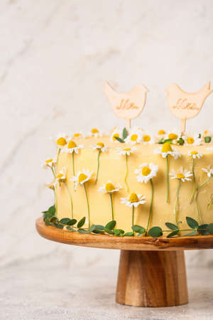 Stand with delicious wedding cake on light tableの写真素材