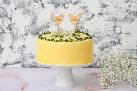 Stand with delicious wedding cake and text MR. Mrs. on table