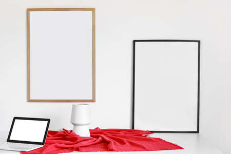 Blank posters hanging on light wall in the room