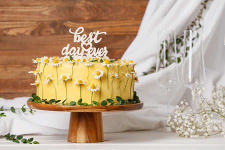 Stand with delicious wedding cake and text BEST DAY EVER on white wooden tableの写真素材
