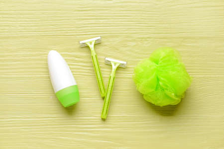 Razors for hair removal, sponge and bottle of deodorant on color wooden backgroundの写真素材