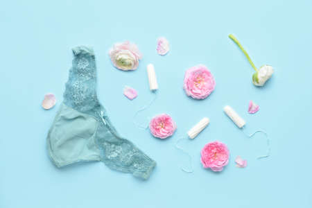 Menstrual tampons, panties and flowers on blue backgroundの写真素材