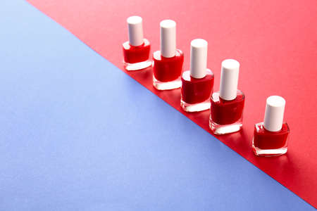 Bottles of nail polishes on color background