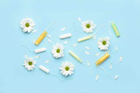 Menstrual tampons and flowers on blue backgroundの写真素材