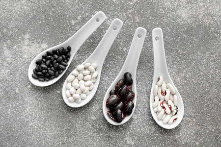 Spoons with raw beans on gray backgroundの写真素材