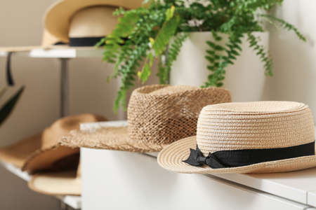 Trendy straw hats on shelf in wardrobe, closeupの写真素材