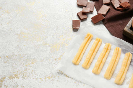 Uncooked churros and chocolate on light grunge backgroundの写真素材