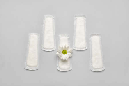 Menstrual pad and chamomile flower on light backgroundの写真素材