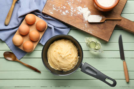Ingredients for preparing churros on color wooden background