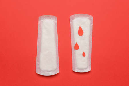 Menstrual pads and drawn blood drops on red backgroundの写真素材
