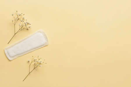 Menstrual pad and flowers on yellow backgroundの写真素材
