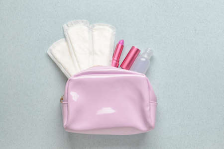 Bag with menstrual pads and lipstick on color backgroundの写真素材